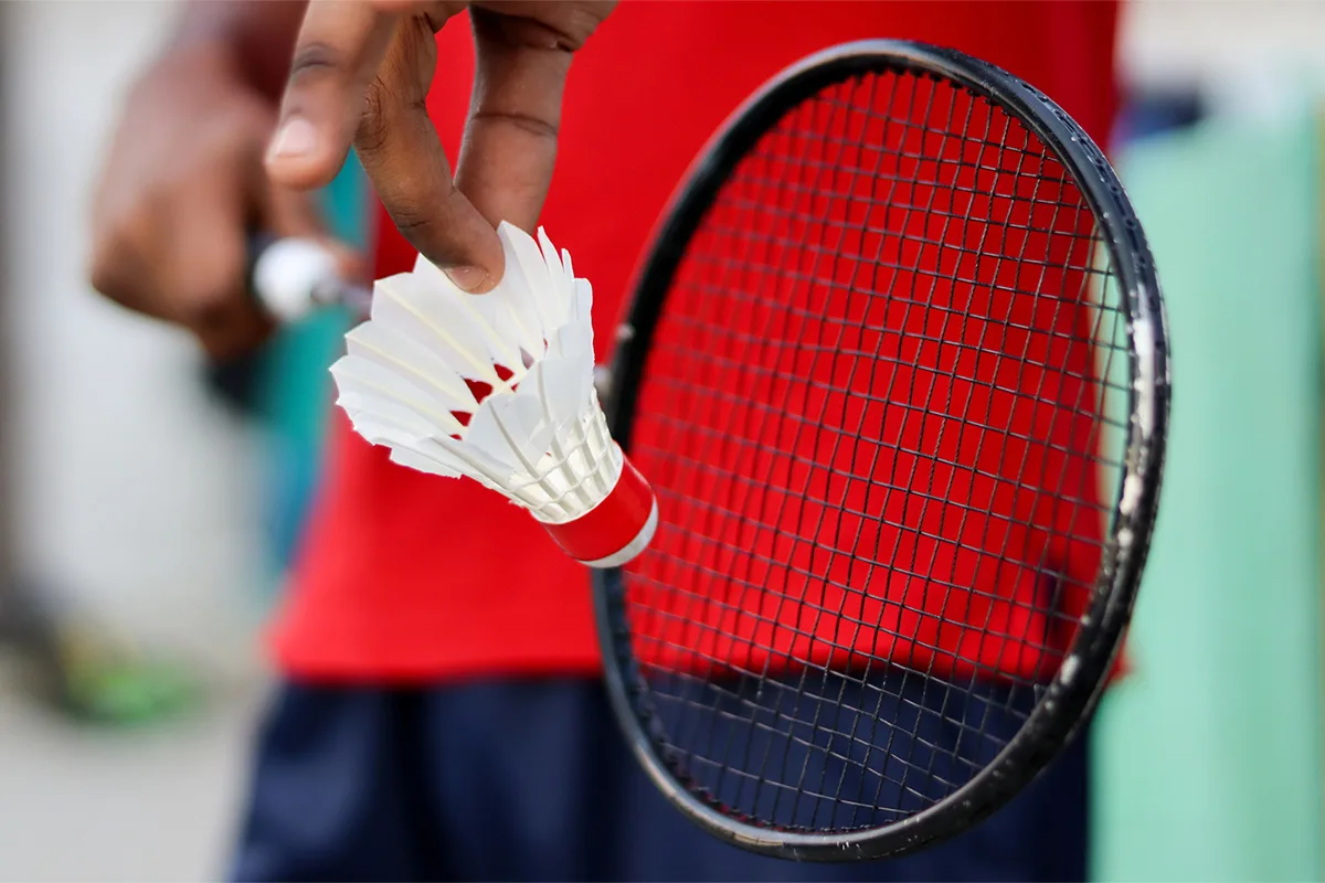 Adults participating in a competitive badminton match at Springfield YMCA, promoting fitness and camaraderie.