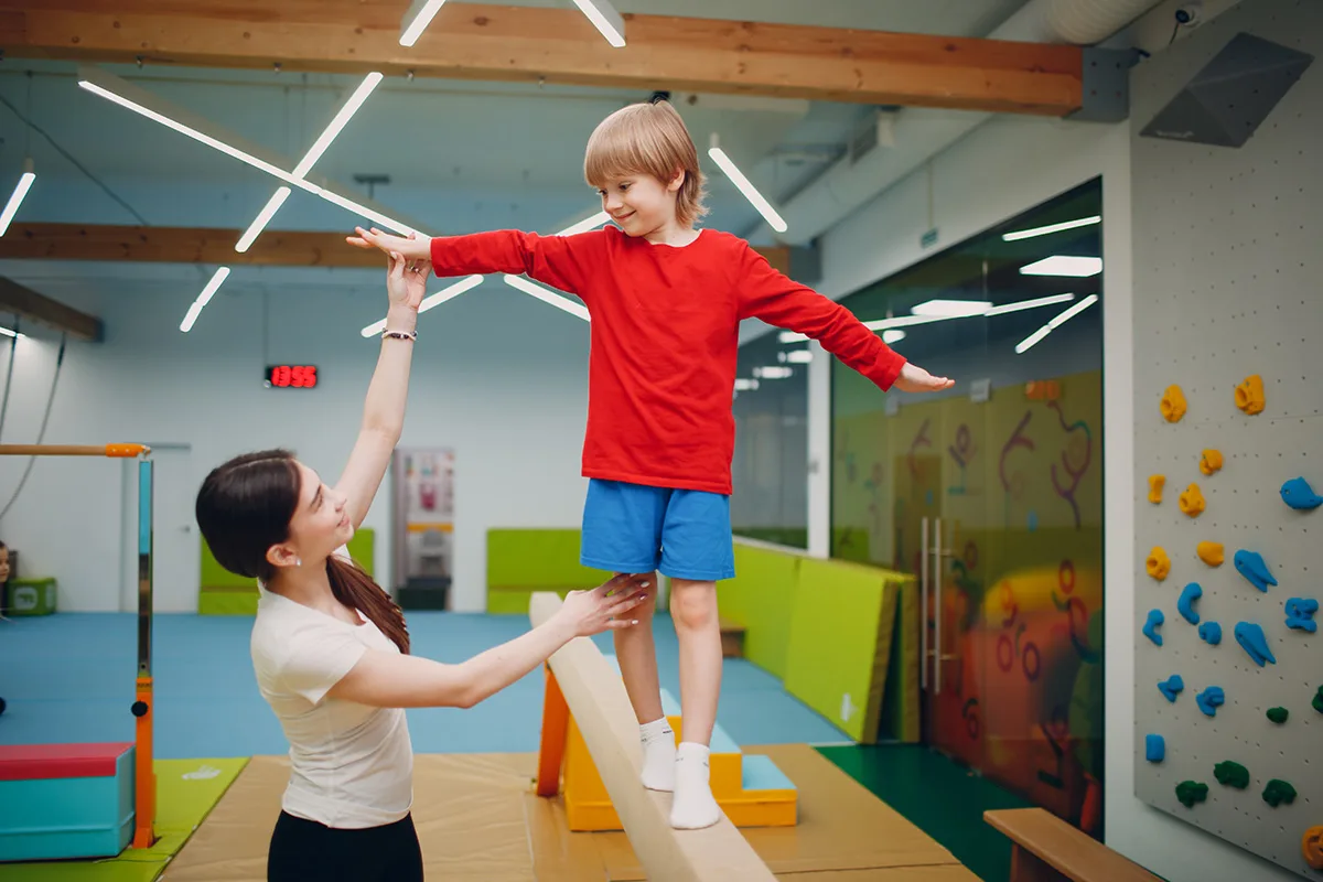 School-age children engaging in beginner gymnastics at Springfield YMCA, improving flexibility and strength.